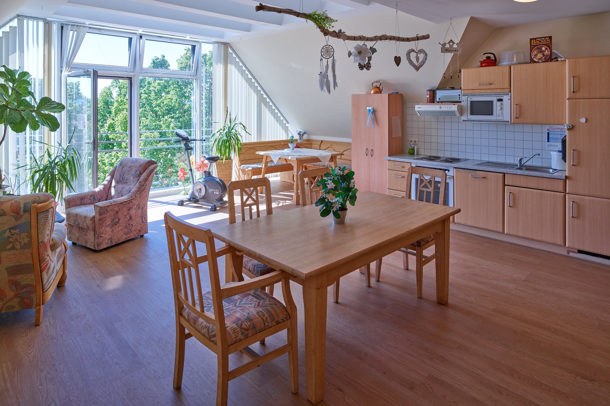 Wohnbereich mit Tisch, Stühlen und Küche